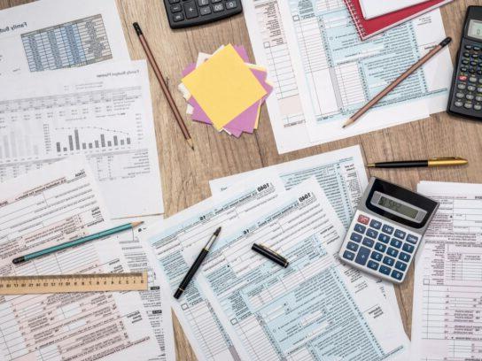 photo of saving concept tax form budget notepad-pen calculator