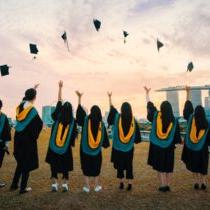 photo of graduates throwing caps in the air